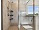 Walk-in shower with adjustable shower head, built-in shelving, and a glass enclosure at 3065 Living Coral Dr, Odessa, FL 33556