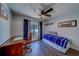 Cozy bedroom with ceiling fan, desk, and large window with blue curtains at 3135 Charter Club Dr # G, Tarpon Springs, FL 34688
