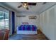 Cozy bedroom featuring ceiling fan, large window, closet and blue curtains at 3135 Charter Club Dr # G, Tarpon Springs, FL 34688