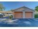Close-up of garages featuring clean asphalt and desert-themed paint at 3135 Charter Club Dr # G, Tarpon Springs, FL 34688
