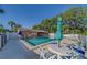 Community pool with lounge chairs, tables and seating with adjacent building with restroom at 3135 Charter Club Dr # G, Tarpon Springs, FL 34688