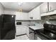 Bright kitchen with stainless steel appliances, tiled backsplash, and white cabinetry at 3241 Fox Chase N Cir # 106, Palm Harbor, FL 34683