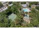 Aerial view of community pool, tennis court and shuffleboard with trees at 3241 Fox Chase N Cir # 106, Palm Harbor, FL 34683