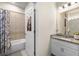 Bright bathroom with shower-tub combo and a door with a fish-themed decoration at 32648 Coldwater Creek Loop, Wesley Chapel, FL 33545