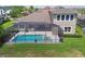 Aerial view of the backyard featuring a screened-in pool and spa with an outdoor living area at 32791 Natural Bridge Rd, Wesley Chapel, FL 33543