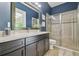Modern bathroom showcasing a sleek vanity, framed mirror, and glass-enclosed shower, designed for comfort and style at 32791 Natural Bridge Rd, Wesley Chapel, FL 33543