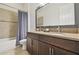Bathroom featuring a double sink vanity, large mirror, and bathtub with shower, perfect for everyday convenience at 32791 Natural Bridge Rd, Wesley Chapel, FL 33543