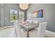 Elegant dining room with decorative light fixture, art and bright natural lighting at 32791 Natural Bridge Rd, Wesley Chapel, FL 33543