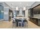 Modern kitchen featuring stainless steel appliances, a large island, dark cabinetry and stylish pendant lighting at 32791 Natural Bridge Rd, Wesley Chapel, FL 33543