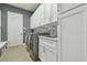 Functional laundry room equipped with modern washer/dryer units, sink, and ample cabinet space for efficient chores at 32791 Natural Bridge Rd, Wesley Chapel, FL 33543