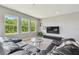 Spacious living room with large windows, a comfortable leather sofa, and entertainment center, ideal for Gathering gatherings at 32791 Natural Bridge Rd, Wesley Chapel, FL 33543