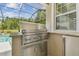 Built-in stainless steel Lynx grill and bar counter located on the screened-in lanai near the pool at 32791 Natural Bridge Rd, Wesley Chapel, FL 33543