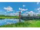 Scenic pond view featuring a charming wooden bridge and picturesque lookout tower enhancing the natural beauty of the community at 32791 Natural Bridge Rd, Wesley Chapel, FL 33543