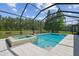 Screened-in pool area with a hot tub, tile flooring, and views of the water at 32791 Natural Bridge Rd, Wesley Chapel, FL 33543