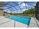 Screened-in pool area with a hot tub, tile flooring, and views of the lake at 32791 Natural Bridge Rd, Wesley Chapel, FL 33543