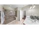 Well-lit bathroom featuring a large glass shower and double sink vanity at 334 Mystic Falls Dr, Apollo Beach, FL 33572