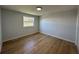 Bright bedroom with light-colored walls, laminate floors, and natural light from the window at 34141 Tree Lake Dr, Wesley Chapel, FL 33543
