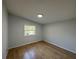 Bright bedroom offers natural light from the window and lovely wood-look laminate flooring at 34141 Tree Lake Dr, Wesley Chapel, FL 33543