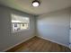 Bedroom with a window view, light walls, wood-look floor and white trim at 34141 Tree Lake Dr, Wesley Chapel, FL 33543