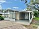 Charming home featuring a screened-in porch and covered carport, perfect for enjoying the outdoors at 34141 Tree Lake Dr, Wesley Chapel, FL 33543