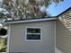 Exterior view of home's vinyl siding, complemented by the surrounding lawn and greenery at 34141 Tree Lake Dr, Wesley Chapel, FL 33543