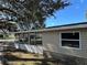 Exterior view of home's vinyl siding, complemented by the surrounding lawn and greenery at 34141 Tree Lake Dr, Wesley Chapel, FL 33543