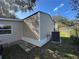 Exterior corner view of home's vinyl siding, complemented by the surrounding lawn and greenery at 34141 Tree Lake Dr, Wesley Chapel, FL 33543