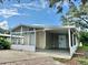 Charming home featuring a screened-in porch and covered carport, perfect for enjoying the outdoors at 34141 Tree Lake Dr, Wesley Chapel, FL 33543