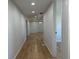 Hallway featuring new wood-look floors, fresh paint, and updated lighting and trim at 34141 Tree Lake Dr, Wesley Chapel, FL 33543