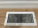 A floor vent in a house with wood-look floors and white trim at 34141 Tree Lake Dr, Wesley Chapel, FL 33543