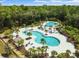 Aerial view of the community's resort-style pool featuring a slide, lounging areas, and lush landscaping at 4194 Bexley Village Dr, Land O Lakes, FL 34638