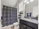 Bathroom featuring a shower with patterned curtain, dark vanity with light granite top, and modern fixtures at 4194 Bexley Village Dr, Land O Lakes, FL 34638