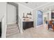 Hallway with stairs and a decorated console table that leads to an open-concept kitchen and dining area at 4194 Bexley Village Dr, Land O Lakes, FL 34638