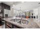Spacious kitchen with stainless steel refrigerator, granite counters, and open view into the living room at 4194 Bexley Village Dr, Land O Lakes, FL 34638