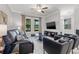 Open-concept living room with a sleek media center, plush leather seating, and lots of natural light at 4194 Bexley Village Dr, Land O Lakes, FL 34638