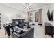 Comfortable living room with black leather furniture, a ceiling fan, and windows for natural light at 4194 Bexley Village Dr, Land O Lakes, FL 34638