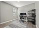 Home office setup with desk, dual monitors, rolling chair, shelving, and a modern rug at 4194 Bexley Village Dr, Land O Lakes, FL 34638