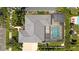Aerial view of a landscaped property with a screened pool, tile roof, and brick driveway at 4301 W Swann Ave, Tampa, FL 33609
