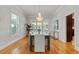 Dining room featuring a large window, hardwood floors, and chandelier with access to the kitchen at 4301 W Swann Ave, Tampa, FL 33609