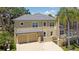 Exterior view of home with a two-car garage, manicured landscaping, and a screened pool area at 4301 W Swann Ave, Tampa, FL 33609