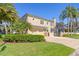 Elegant two-story home with a paved driveway, lush landscaping, and a screened pool enclosure at 4301 W Swann Ave, Tampa, FL 33609