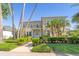 Two-story home featuring manicured landscaping, palm trees and a second story balcony on a sunny day at 4301 W Swann Ave, Tampa, FL 33609