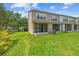 The backyard features a lush green lawn, screened patio, and is surrounded by mature trees, providing a serene outdoor space at 4516 Barnstead Dr, Riverview, FL 33578