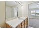 Bathroom featuring a vanity, mirror, lighting and an open view into the connected bedroom at 4516 Barnstead Dr, Riverview, FL 33578