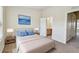 Cozy bedroom featuring a bed, nightstands, artwork, carpet and view into the ensuite bathroom at 4516 Barnstead Dr, Riverview, FL 33578