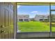 Screened-in patio view shows lush green lawn and neighboring buildings at 4516 Barnstead Dr, Riverview, FL 33578