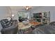 Comfortable living room features a large leather sofa, reclining chairs, and view of screened patio at 4916 Chatham Gate Dr, Riverview, FL 33578