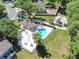 Aerial view of a community pool with a bathhouse, ample seating, playground, and lush green space at 5116 Corvette Dr, Tampa, FL 33624