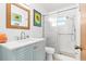 Bathroom boasts a vanity with storage, sunflower artwork, and a glass-enclosed shower for a refreshing experience at 525 Lillian Dr, Madeira Beach, FL 33708