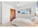 Bright bedroom featuring a ceiling fan, window view, and closet with paneled sliding doors at 525 Lillian Dr, Madeira Beach, FL 33708